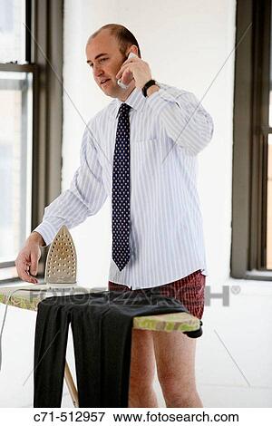 Man in underwear ironing his clothes, talking on cell phone View Large Photo Image Stock Photo - Man in underwear ironing his clothes, talking on cell phone. Fotosearch