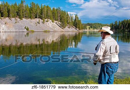 Man in water fly fishing for trout in beautiful scene in Yellowstone National Park in Wyoming at Hayden Valley View Large Photo Image Stock Photo - Man in water fly fishing for trout in beautiful scene in Yellowstone National Park in Wyoming at Hayden Valley. Fotosearch