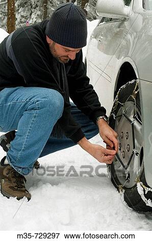 Man installing snow chains during winter View Large Photo Image Stock Photo - Man installing snow chains during winter. Fotosearch