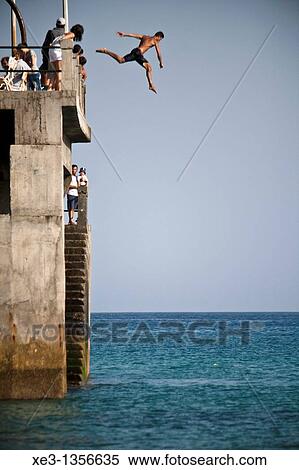 Stock Photography - Man jumping from the dock, Porto santo, Madeira. Fotosearch