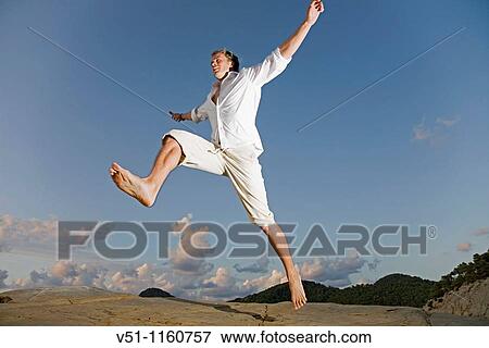 Man jumping in a cliff in Ibiza View Large Photo Image Stock Photo - Man jumping in a cliff in Ibiza. Fotosearch