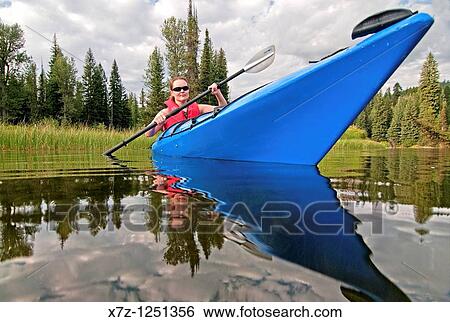 Stock Photograph - Man kayaking on the North Fork of the Payette River near Payette Lake and the city of McCall in the Salmon River Mountains of central Idaho. Fotosearch