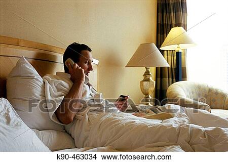 Man laying in bed having a telephone call View Large Photo Image Picture - Man laying in bed having a telephone call. Fotosearch