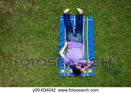 Man laying on grass View Large Photo Image Stock Image - Man laying on grass. Fotosearch