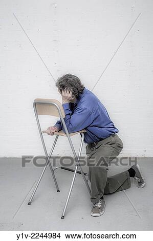 Man leaning on a chair. View Large Photo Image Picture - Man leaning on a chair.. Fotosearch