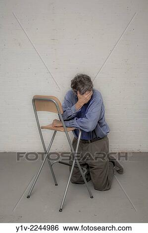Man leaning on a chair. View Large Photo Image Stock Photograph - Man leaning on a chair.. Fotosearch