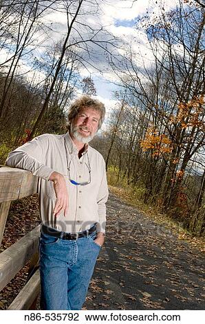 Man leaning on rail outdoors View Large Photo Image Stock Image - Man leaning on rail outdoors. Fotosearch