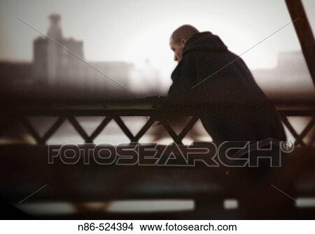 Man leaning on railing, moody View Large Photo Image Picture - Man leaning on railing, moody. Fotosearch