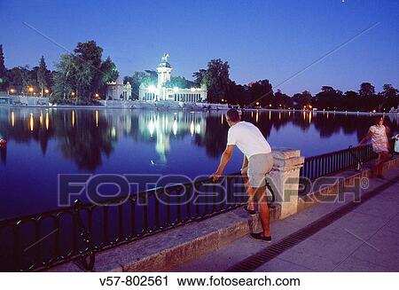 Man leant on the banister looking at the pond, night view. The Retiro park, Madrid, Spain. View Large Photo Image Stock Image - Man leant on the banister looking at the pond, night view. The Retiro park, Madrid, Spain.. Fotosearch