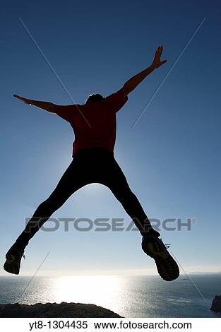 Man leaping through the air by the sea View Large Photo Image Stock Photography - Man leaping through the air by the sea. Fotosearch