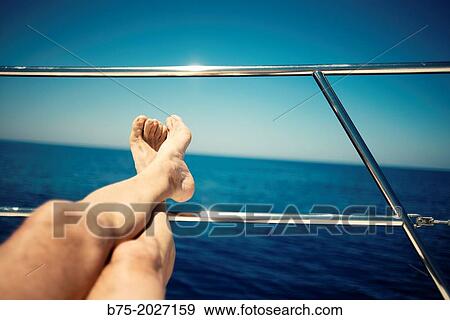 man legs resting on a railing of a sailing boat in a relaxed posture. View Large Photo Image Stock Photo - man legs resting on a railing of a sailing boat in a relaxed posture.. Fotosearch
