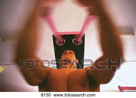 Stock Image - Man lifting weights. Fotosearch