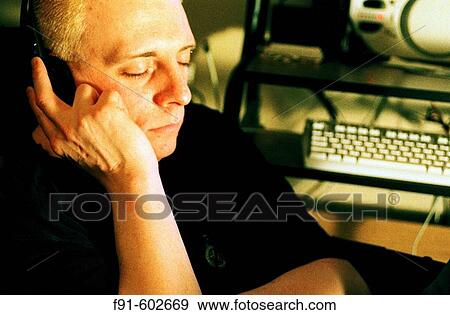 Man listening to music downloaded to computer View Large Photo Image Stock Photo - Man listening to music downloaded to computer. Fotosearch