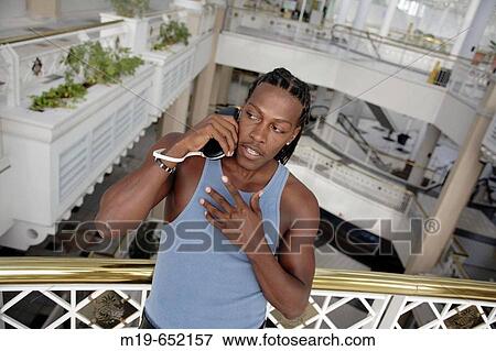 Stock Photo - Man listening to music on an MP player. Fotosearch