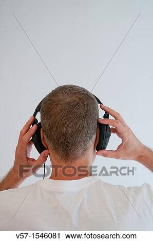 Man listening to music, using earphones View Large Photo Image Stock Image - Man listening to music, using earphones. Fotosearch