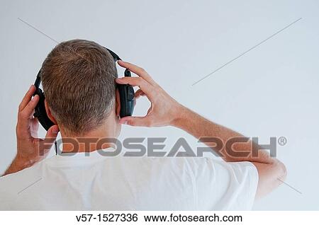 Stock Photograph - Man listening to music, using earphones.. Fotosearch