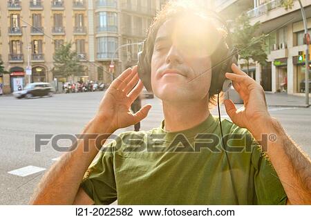 Stock Image - Man listening to music with headphones on a street.. Fotosearch