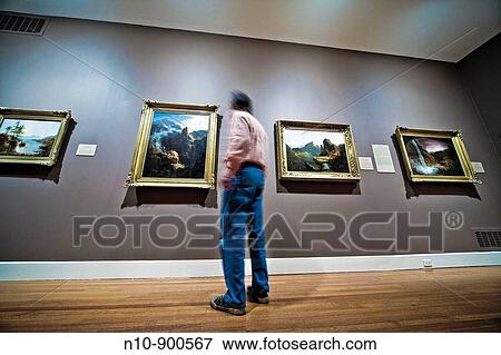 Man looking at paintings in a museum. View Large Photo Image Stock Photo - Man looking at paintings in a museum.. Fotosearch