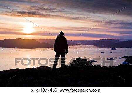 Man looking at the fjord outside Narsaq, South Greenland View Large Photo Image Stock Photograph - Man looking at the fjord outside Narsaq, South Greenland. Fotosearch