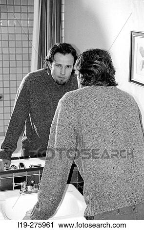 man looking in bathroom mirror View Large Photo Image Stock Image - man looking in bathroom mirror. Fotosearch