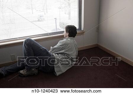 Man looking out his office window View Large Photo Image Stock Image - Man looking out his office window. Fotosearch