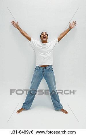 Stock Photograph - Man looks up towards the light in a studio. Fotosearch