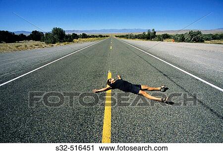 Man lying down on the road. Nevada; USA View Large Photo Image Stock Image - Man lying down on the road. Nevada; USA. Fotosearch