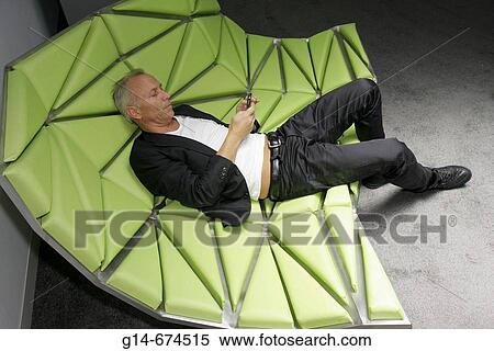 Man lying in a sofa. View Large Photo Image Stock Photography - Man lying in a sofa.. Fotosearch