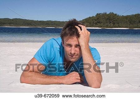 Stock Photo - Man lying on a beautiful beach. Fraser Island, Australia. Fotosearch