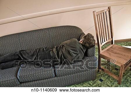 Stock Photo - Man lying on a sofa in a college lounge. Fotosearch