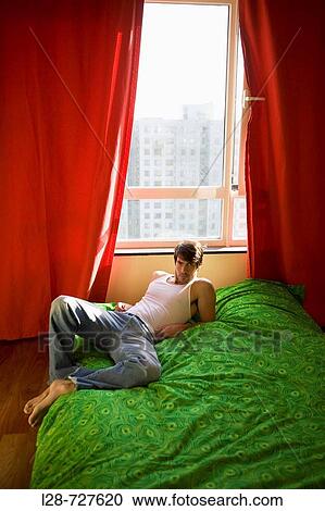 Man lying on bed View Large Photo Image Stock Image - Man lying on bed. Fotosearch