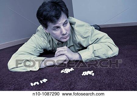 Man lying on the floor near a bunch of pills View Large Photo Image Stock Image - Man lying on the floor near a bunch of pills. Fotosearch