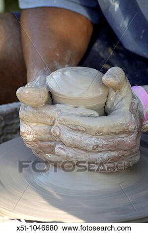 Man making a clay pot on a potters wheel View Large Photo Image Stock Image - Man making a clay pot on a potters wheel. Fotosearch