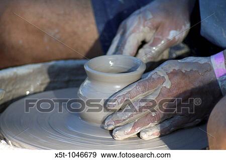Stock Photo - Man making a clay pot on a potters wheel. Fotosearch