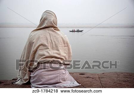 Man meditating over Ganges river in a cold morning Varanasi, India View Large Photo Image Stock Photo - Man meditating over Ganges river in a cold morning Varanasi, India. Fotosearch