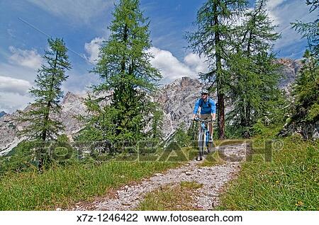 Stock Image - Man mountain biking at Crepe De Zumeles near Rifugio Son Forcia below Cima De Meso Cristallo high above the city of Cortina in northern Italy. Fotosearch