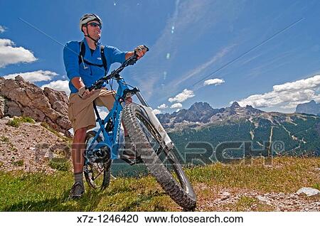 Man mountain biking at Rifugio Son Forcia below Cima De Meso Cristallo high above the city of Cortina in northern Italy View Large Photo Image Stock Image - Man mountain biking at Rifugio Son Forcia below Cima De Meso Cristallo high above the city of Cortina in northern Italy. Fotosearch