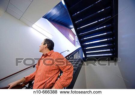 Man next to a stairwell in an office building. View Large Photo Image Stock Photo - Man next to a stairwell in an office building.. Fotosearch