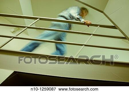 Man on a walkway in an office building View Large Photo Image Stock Photo - Man on a walkway in an office building. Fotosearch
