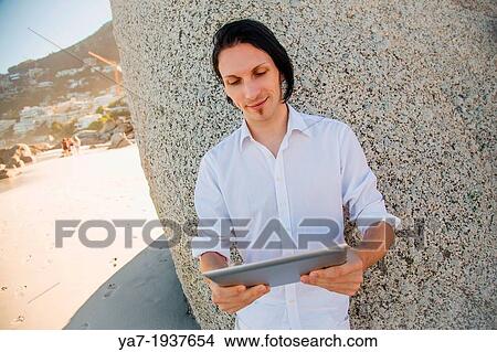Man On Beach Using Ipad View Large Photo Image Picture - Man On Beach Using Ipad. Fotosearch