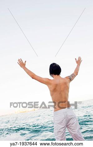 Man on Beach with Hands up View Large Photo Image Picture - Man on Beach with Hands up. Fotosearch