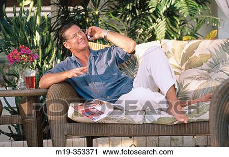 Stock Image - man on cell phone relaxing outdoors. Fotosearch
