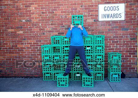 Man on crates, covering his face View Large Photo Image Picture - Man on crates, covering his face. Fotosearch