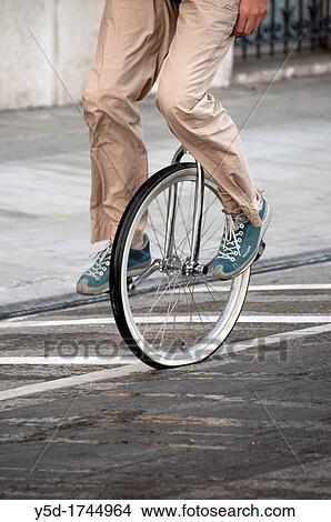 Picture - man on monocycle, unicycle, street in Geneva, Switzerland. Fotosearch