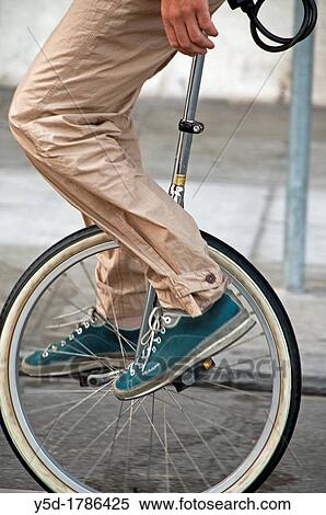 Stock Photography - man on monocycle, unicycle, street in Geneva, Switzerland. Fotosearch