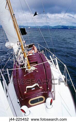 Man on sailboat at sea View Large Photo Image Stock Image - Man on sailboat at sea. Fotosearch