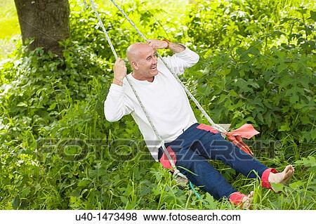 Stock Photo - Man on swing. Fotosearch