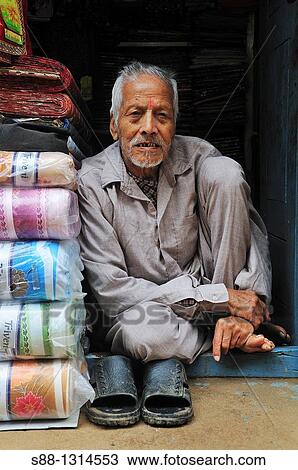 Stock Image - Man on the shopping street siting quietly. Fotosearch