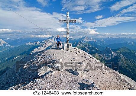Man on the summit after climbing the Giovanni Lipella via ferrata on Tofana De Rozes in the Dolomite Mountains near the city of Cortina in northern Italy View Large Photo Image Stock Photo - Man on the summit after climbing the Giovanni Lipella via ferrata on Tofana De Rozes in the Dolomite Mountains near the city of Cortina in northern Italy. Fotosearch