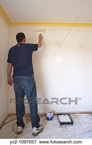 Man painting the interior of a room using a roller in the Uk View Large Photo Image Stock Photo - Man painting the interior of a room using a roller in the Uk. Fotosearch